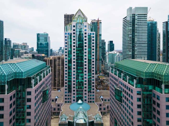 Cityscape with modern high-rise buildings, glass facades, geometric patterns, triangular roof.