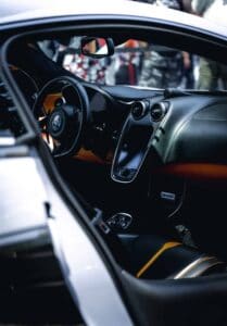 Luxury Sports Car Interior Luxury sports car interior with logo steering wheel, sleek dashboard, touchscreen, leather seats.