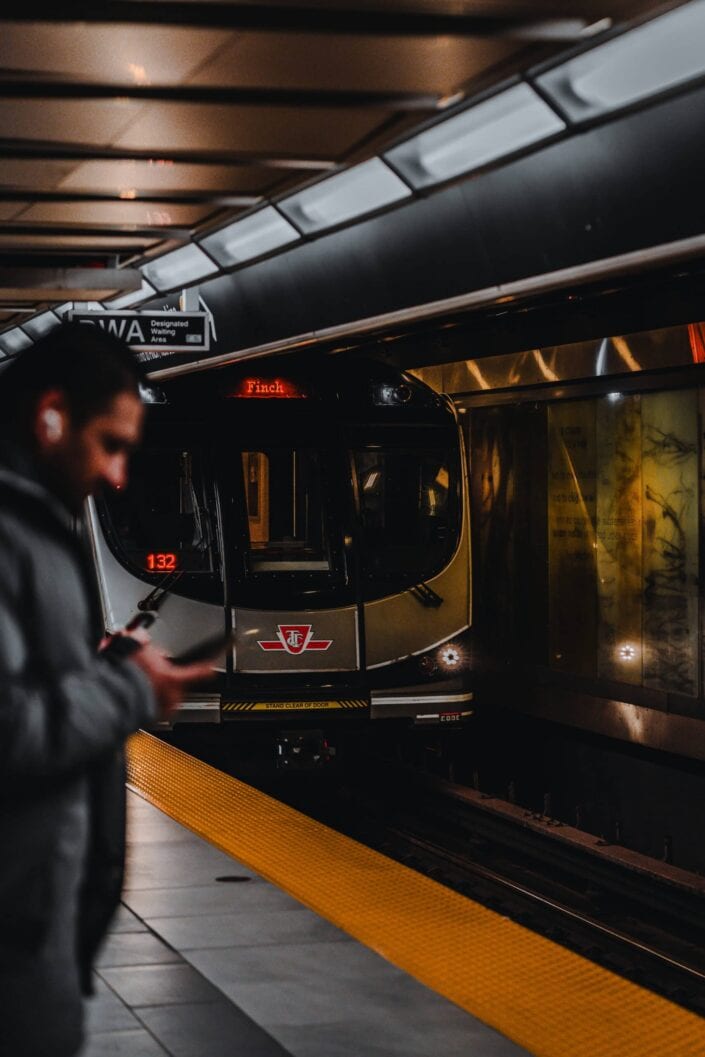A shot of a man standing on the subway platform as the train approaches.